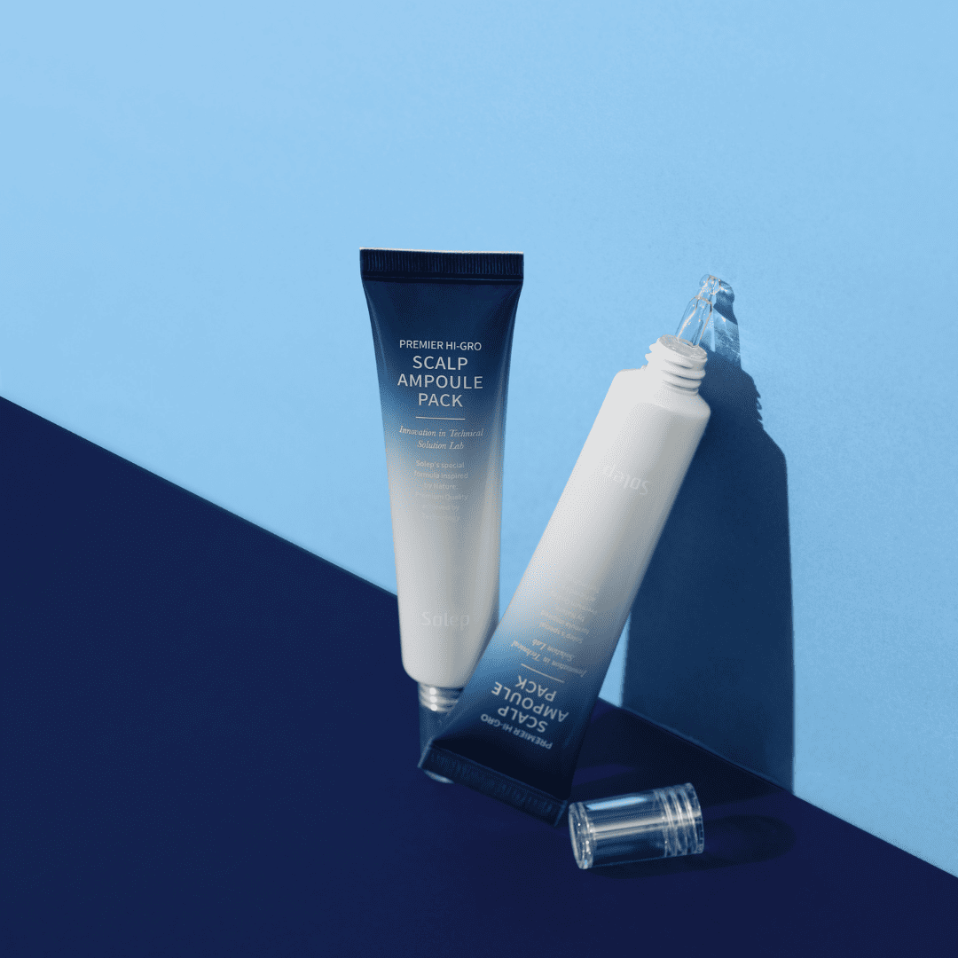 На фото на синій поверхні та блакитному фоні зображені дві ампули Solep Premier Hi-gro Scalp: одна закрита, а інша відкрита.