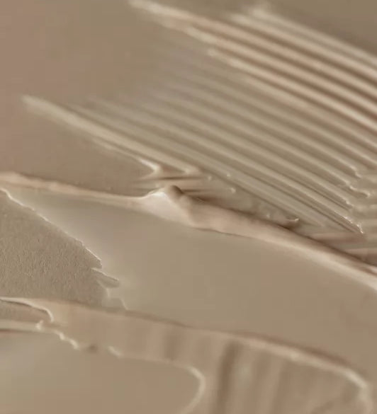 Бежева кремова текстура засобу Aromatica Quinoa Protein Treatment Mask, покриває бежеву поверхню