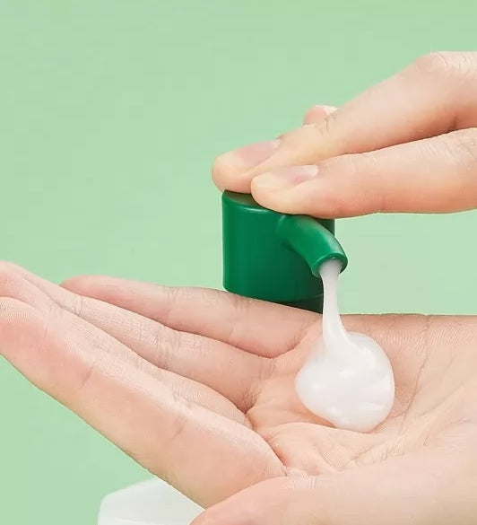 Ніжна біла гелева текстура шампуню LABO-H для волосся на долоні, видавлена з флакона із зеленим дозатором