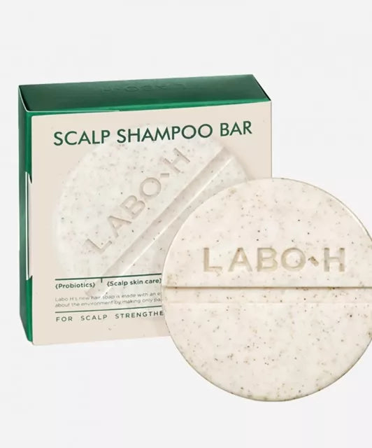 Твердий шампунь LABO-H у зручній круглій формі бежевого кольору з темними вкрапленнями, на фоні упаковка