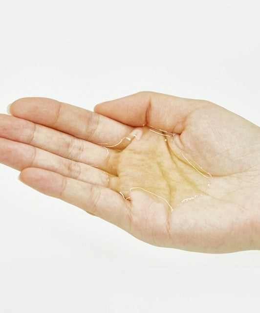 На долоню налита ніжна текстура засобу Ma:nyo Herb Cleansing Oil.