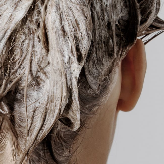 Напінене волосся густою білою піною, яка рівномірно його покриває