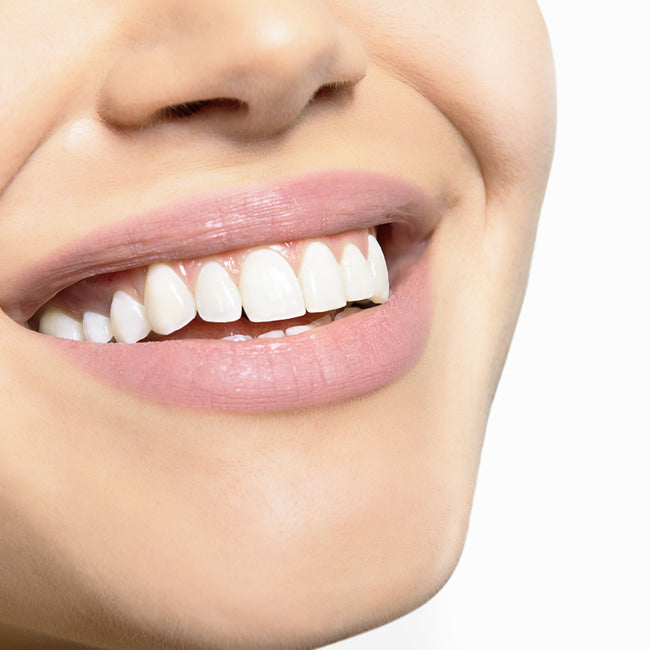 На фото зображена усмішка людини з білими зубами.