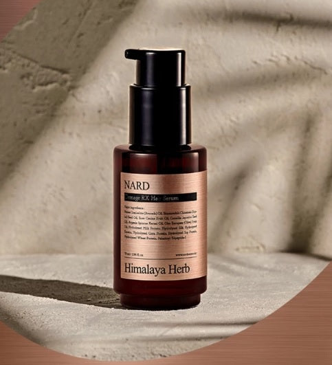 Коричнево-прозора бутилочка з чорним дозатором серуму для волосся NARD Damage RX Hair Serum стоїть на бетонній поверхні.