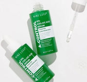 Дві ампули сироватки Nine Less A-Control 10% Azelaic Acid Serum — одна відкрита, інша закрита — лежать на білій поверхні, поряд з відкритою ампулою знаходиться піпетка.