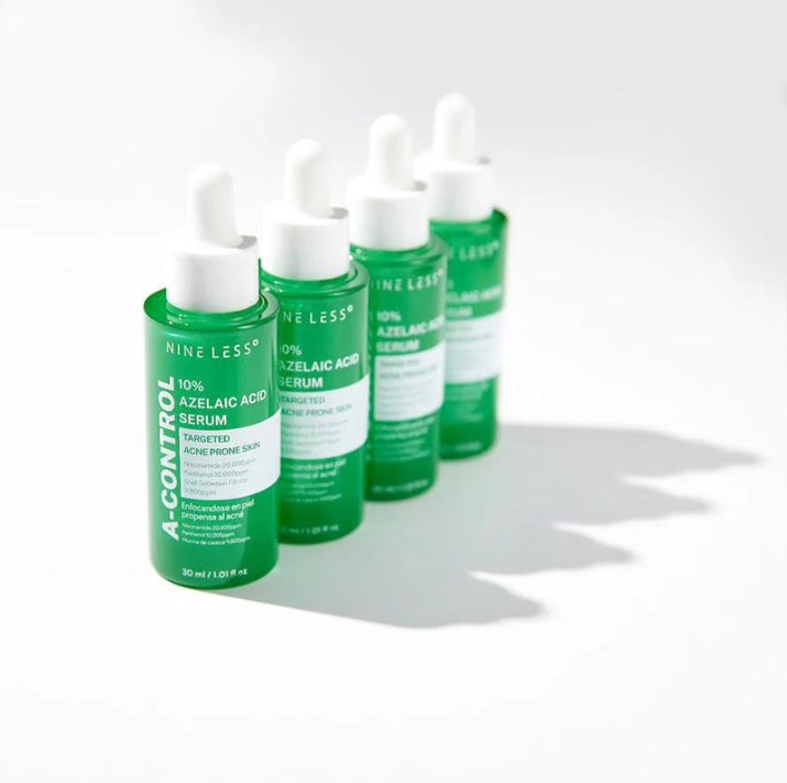 Чотири ампули сироватки Nine Less A-Control 10% Azelaic Acid Serum стоять у ряд на білій поверхні.