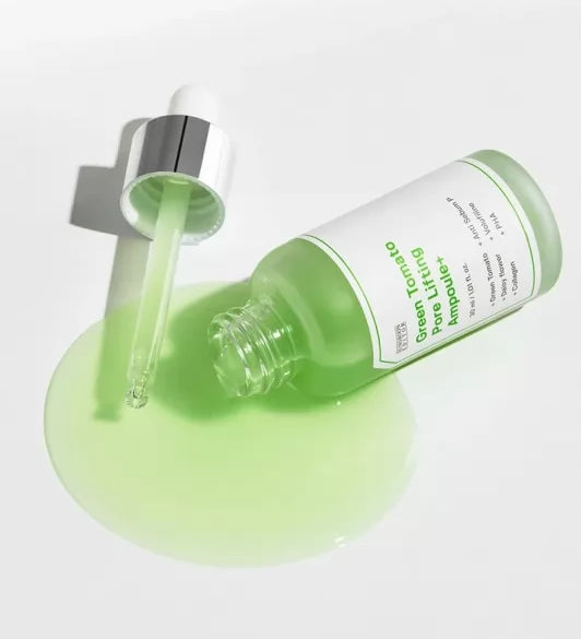 Відкрита зелена ампула SUNGBOON Editor Green Tomato Pore Lifting Ampoule лежить на білій поверхні, з неї витікає сироватка, поруч — піпетка.