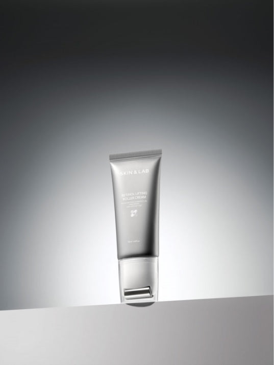 Сірий тюбик з білою роликовою насадкою крему Skin&Lab Retinol Lifting Roller Cream стоїть на білому подіумі на сірому фоні.