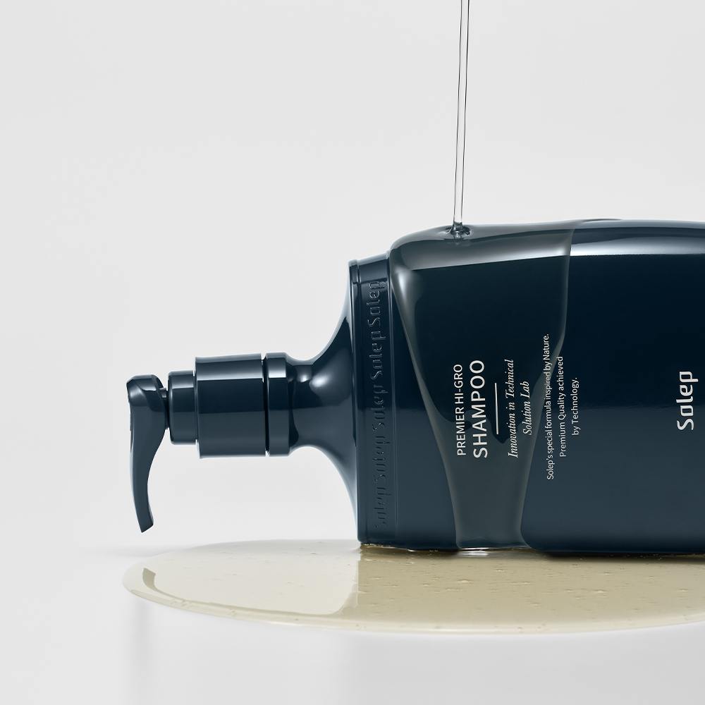 Темно-синій флакон шампуню Solep Premier Hi-gro з темно-синім дозатором лежить на нього розлитий с гелевою структурою шампунь