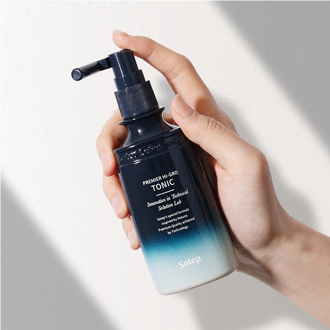 Пляшечка засобу Solep Premier Hi-gro Tonic в руці людини.