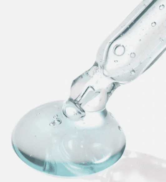 З піпетки Torriden Dive-In Low Molecular Hyaluronic Acid Skin Serum на білу поверхню нанесена блакитна сироватка.