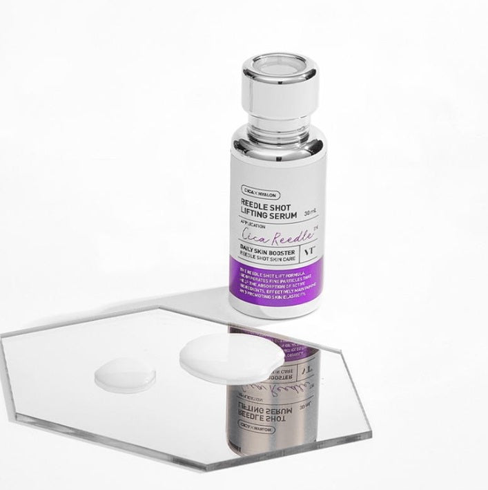 Срібляста ампула VT Cosmetics Reedle Shot Lifting Serum стоїть біля дзеркала, на якому нанесена текстура сироватки.
