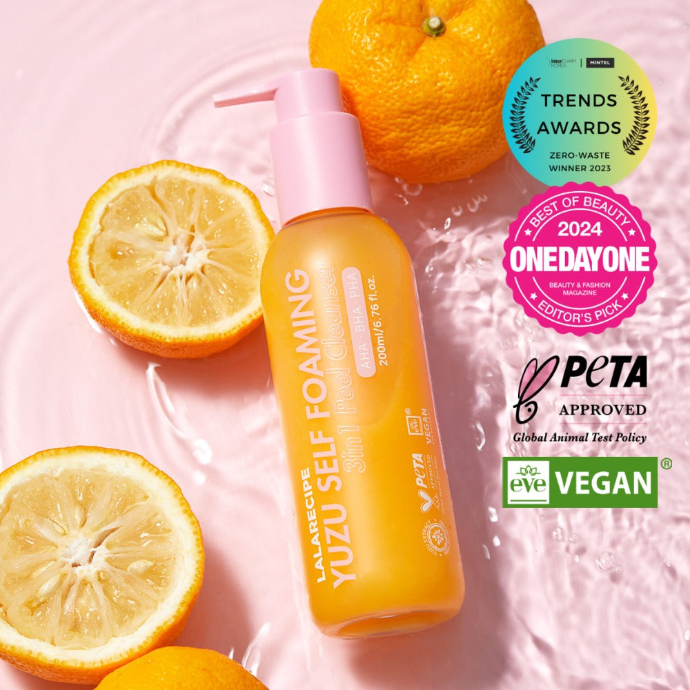 Освітлювальна пінка для вмивання з юдзу LALARECIPE на мармуровому фоні з часточками юдзу