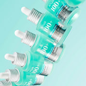 Сім флаконів сироватки ANUA PDRN Hyaluronic Acid Capsule 100 Serum розташовані один над одним на бірюзовому фоні.