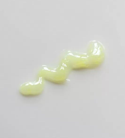 На білу поверхню нанесена текстура Goodal Green Tangerine Vita C Dark Spot Sun Care Serum SPF 50+ PA++++.