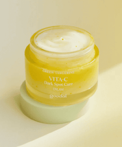Відкрита баночка крему Goodal Green Tangerine Vita C Dark Spot Care Cream стоїть на кришечці, на жовтому фоні.