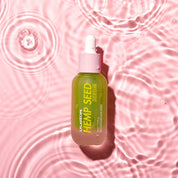 Пляшечка LALARECIPE Hemp Seed Serum з білою піпеткою лежить у воді.