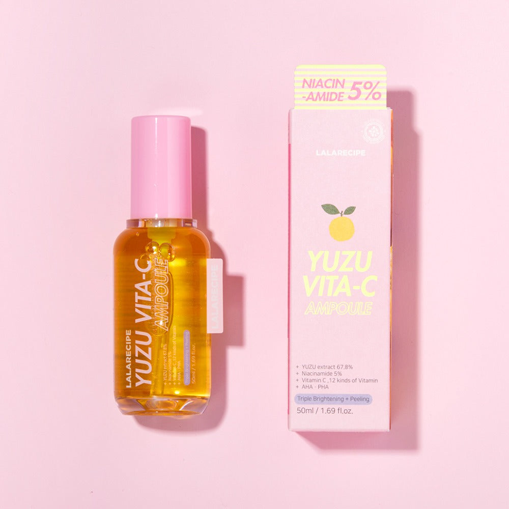 Прозора ампула сироватки LALARECIPE Yuzu Vita C Ampoule з рожевою кришечкою лежить поруч з упаковкою на рожевій поверхні.