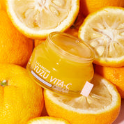 Відкрита баночка крему LALARECIPE Yuzu Vita C Cream лежить на плодах юдзу