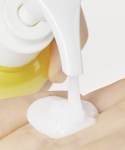 З білого дозатора засобу Ma:nyo Pure Cleansing Milk видавлюється на долоню біла гелева текстура.