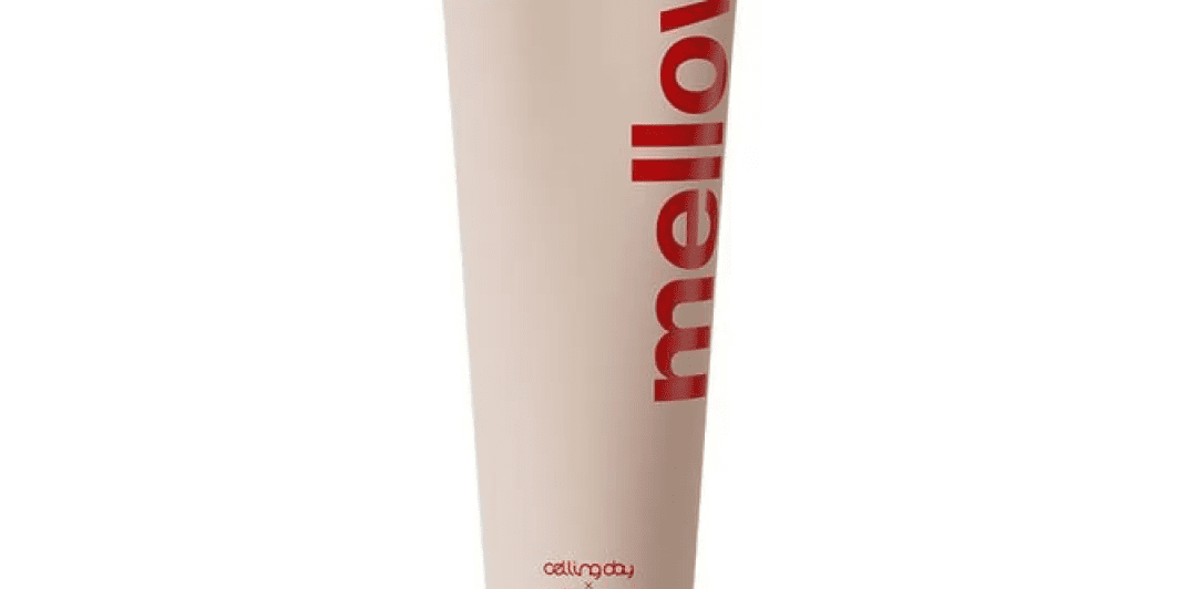 Бежевий тюбик крему Mellow Bloom Calming Cream з червоними написами стоїть на білому фоні.