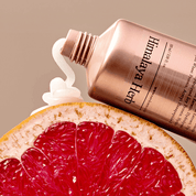 Ніжна біла кремова текстура засобу NARD Damage RX No Wash Treatment видавлена з тюбику на шкірку розрізанного навпіл грейпфрута, 100мл