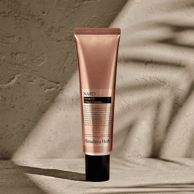 Бронзовий тюбик засобу NARD Damage RX No Wash Treatment з чорним носиком і кришечкою на бетонній поверхні і фоні, 100мл
