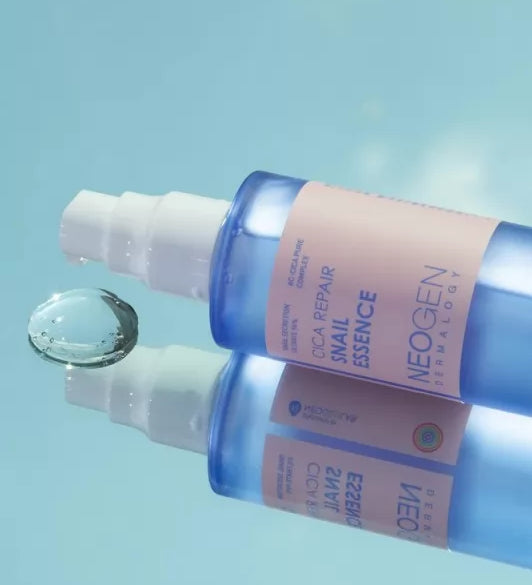 Синя пляшечка Neogen Dermalogy Cica Repair Snail Essence лежить на дзеркальній поверхні, під білим дозатором видно нанесену прозору есенцію.