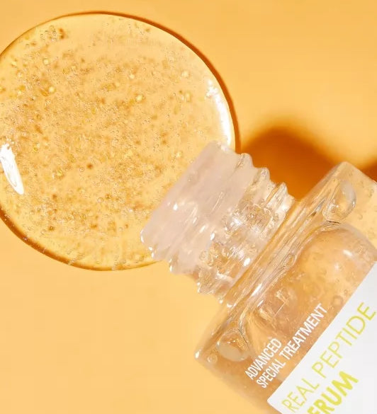 Відкрита ампула сироватки Neogen Dermalogy Real Peptide Serum лежить на оранжевій поверхні, з неї витікає сироватка.