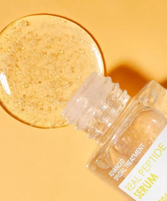 Відкрита ампула сироватки Neogen Dermalogy Real Peptide Serum лежить на оранжевій поверхні, з неї витікає сироватка.