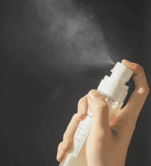 Людина натискає на спрей-дозатор пляшки NEOGEN DERMALOGY WHITE TRUFFLE AMPOULE DROP MIST, розпилюючи міст.