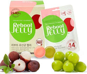На фото зображена коробка REBOOT Probiotic Gummies Reboot Jelly та пакетик, розташовані на передньому плані, поряд з ними видно фрукти лічі