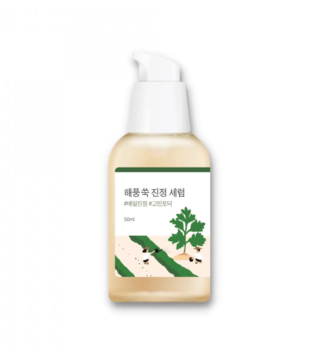 Бежева пляшечка з білим дозатором сироватки ROUND LAB Mugwort Calming Serum стоїть на білому фоні.