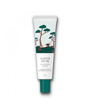Тюбик крему Round Lab Pine Calming Cica Cream на білому фоні. На тюбику зображені дерева, дівчина на гамаку та шишки на траві.