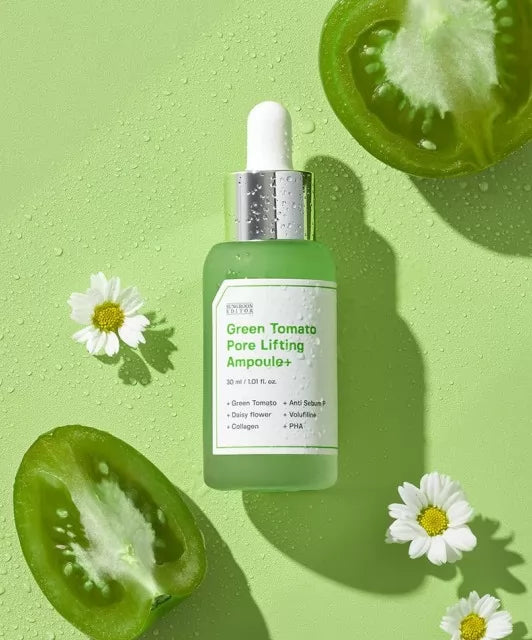 Ампула SUNGBOON Editor Green Tomato Pore Lifting Ampoule лежить на зеленій поверхні, поруч розташовані ромашки та порізані зелені помідори.