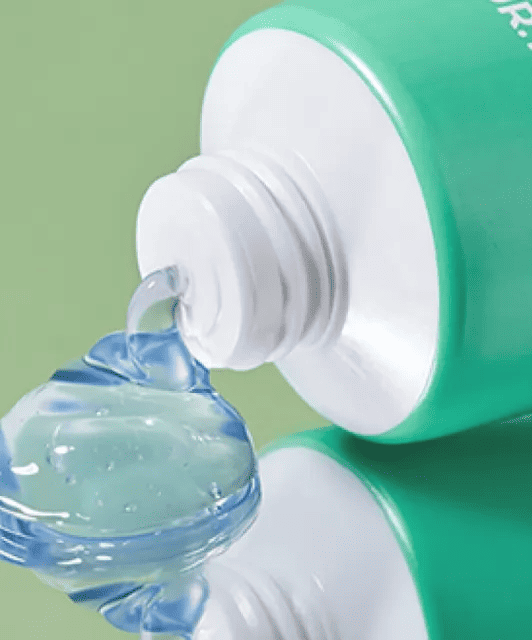 З відкритого тюбика крему Azulene Soothing PH Cleanser плавно витиснута синьо-прозора текстура крему на дзеркальній поверхні.