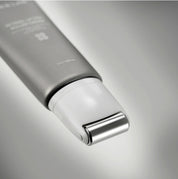Сірий тюбик з білою роликовою насадкою крему Skin&Lab Retinol Lifting Roller Cream лежить на сірій поверхні.