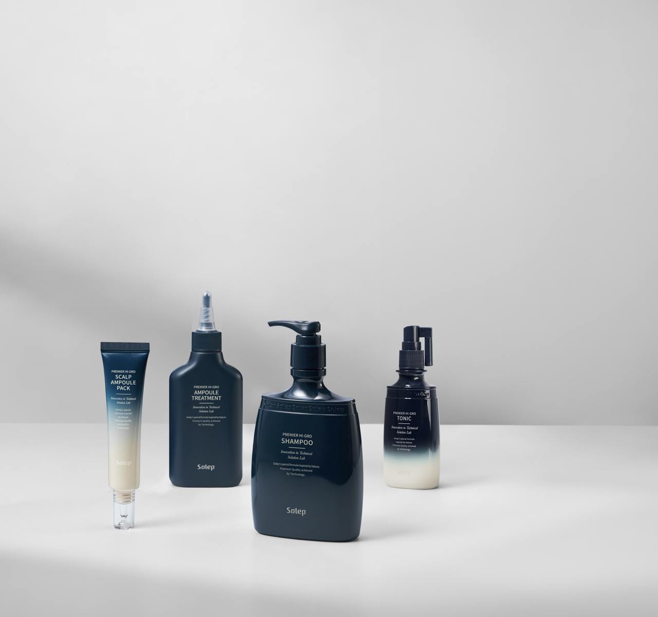 Чотири засоби стоять на білій поверхні: Solep Premier Hi-gro Ampoule Treatment, Solep Premier Hi-gro Scalp Ampoule Pack, Solep Premier Hi-gro Tonic, та Solep Premier Hi-gro Shampoo.