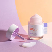 Відкрита баночка крему Neogen Dermalogy V.Biome Soothing Cream стоїть на рожево-оранжевій поверхні, поряд — намазана текстура крему так кришечка.