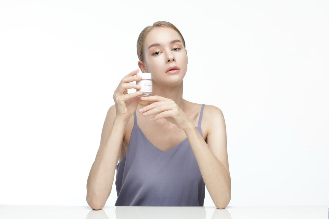 Модель розглядає крем Neogen V.Biome Soothing Cream – пробіотики для здорового сяйва шкіри
